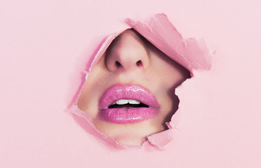 Picture of a woman's mouth through a pink sheet of paper