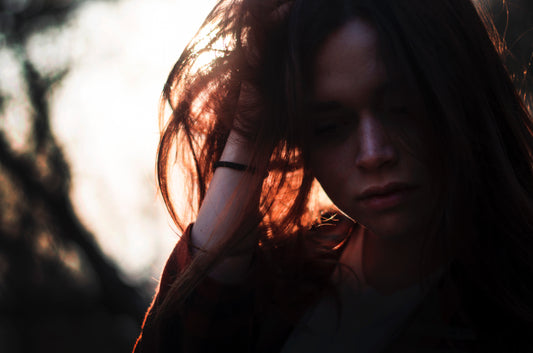 Woman with hand in hair looking distressed via Unsplash